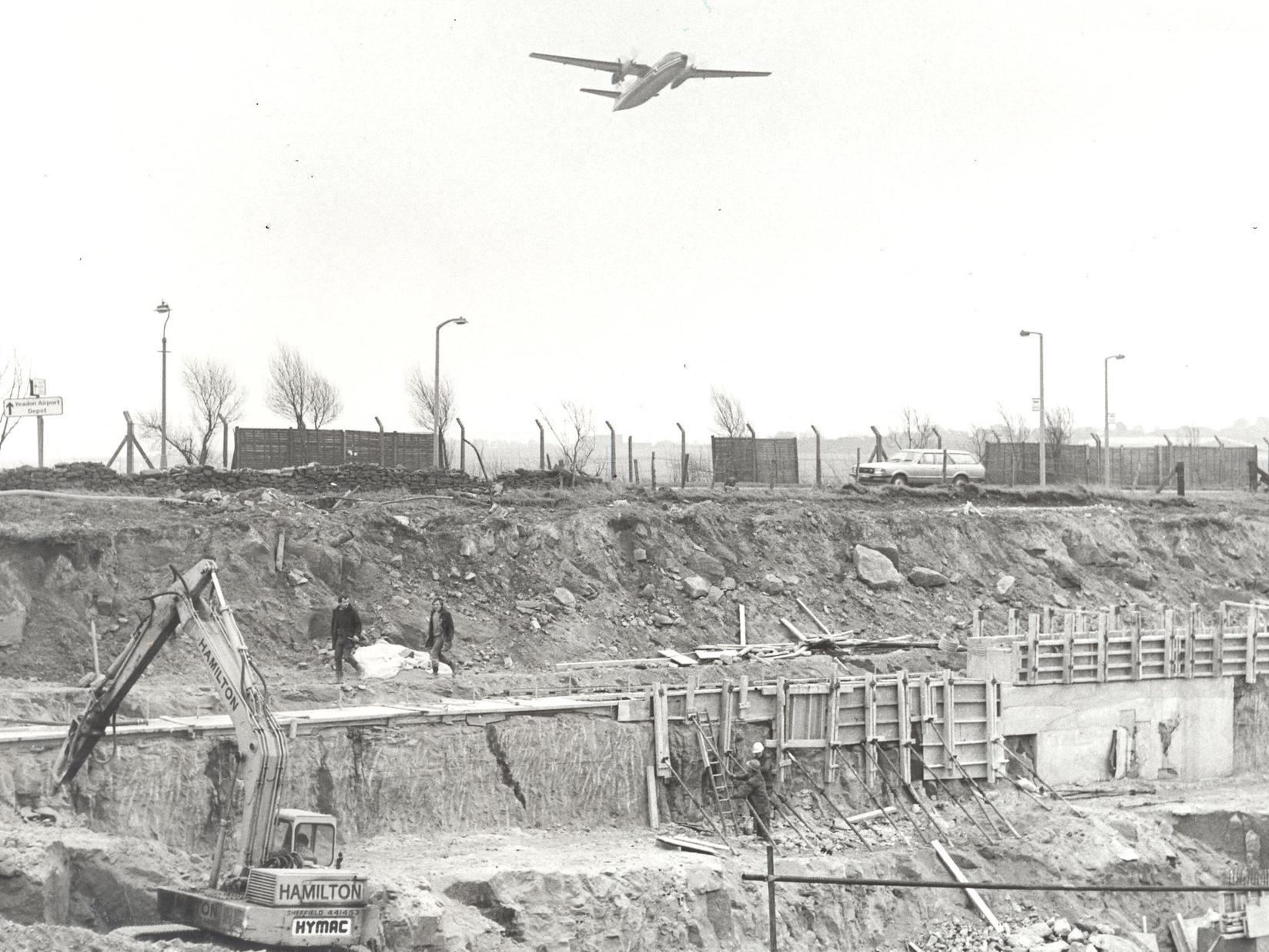 Aircraft taking off immediately pass over the site of the runway extension. In the foreground can be seen the excavation in which the tunnel is being built to carry the Bradford/Harrogate road beneath the runway.
