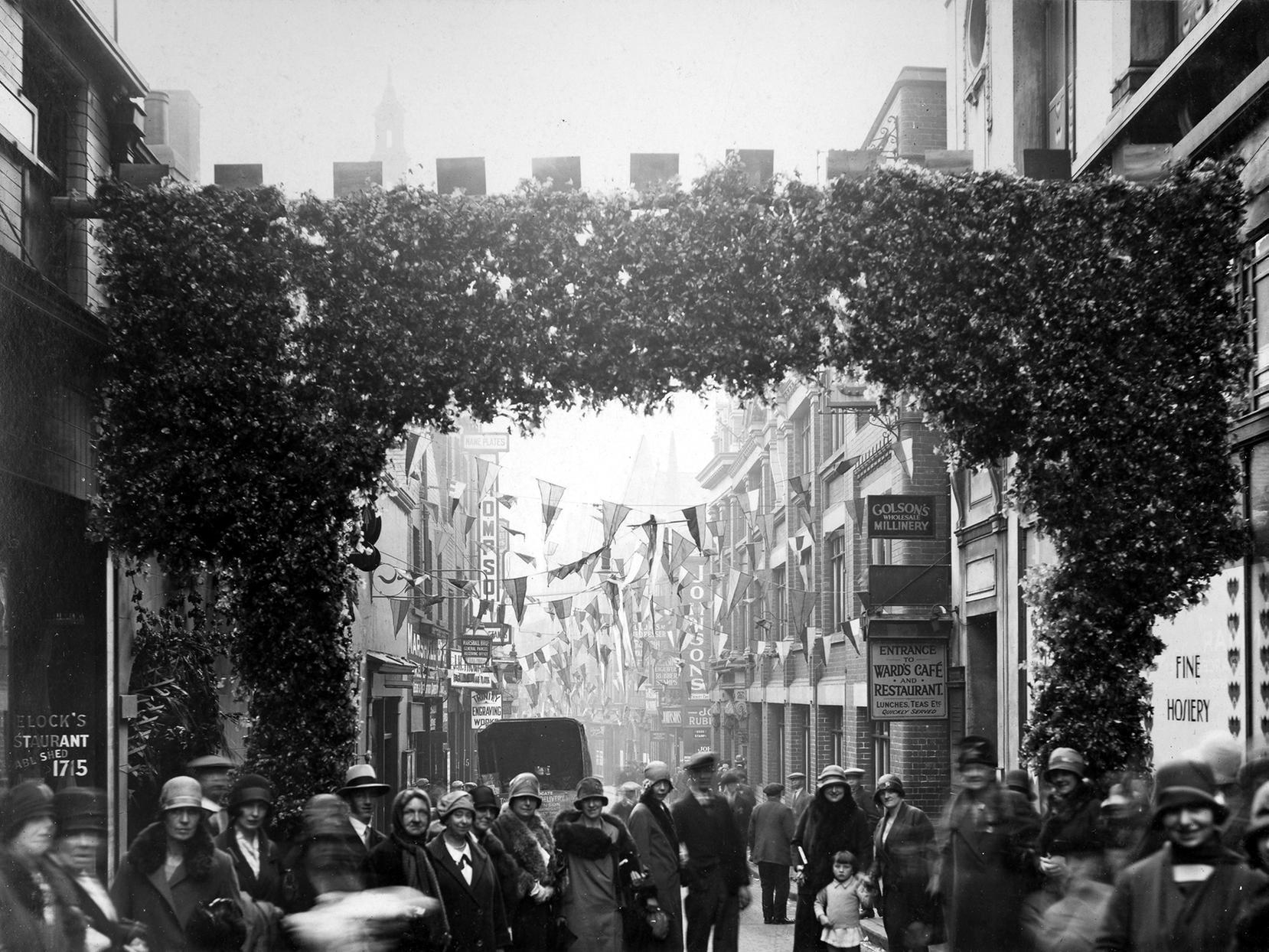 Another photo from Civic Week. In this view, Trinity Street can be seen. Entered through an evegreen arch, the street is decked with bunting and busy with people.