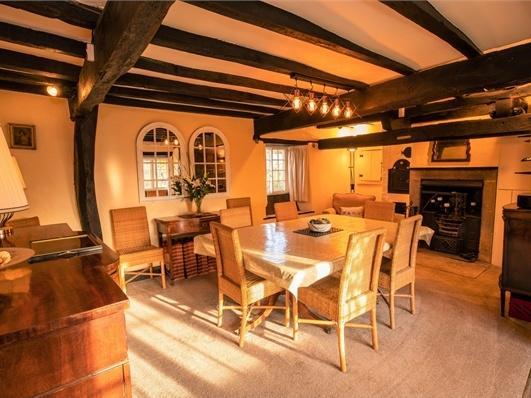 The oak beams can be seen in the ceiling of the well proportioned dining room which features a cast iron fire.