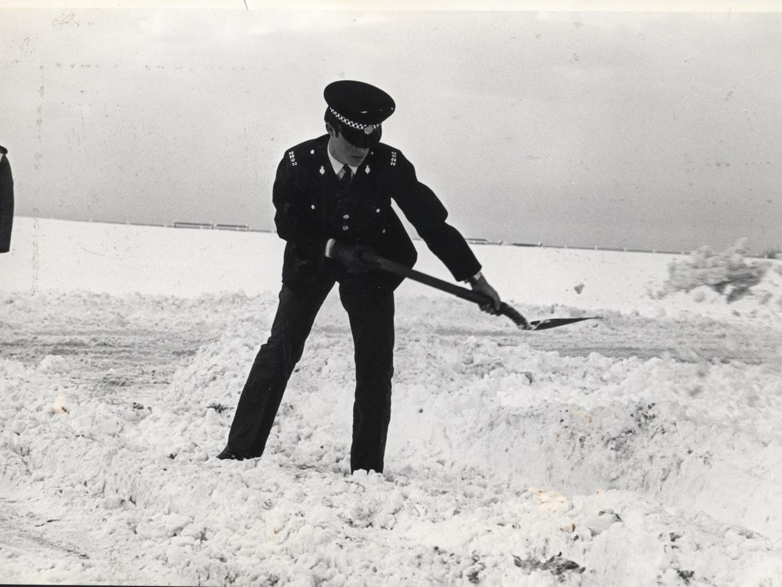 PC Ian Dover keeps himself warm by shovelling snow from the roads near the front at Lytham 1982