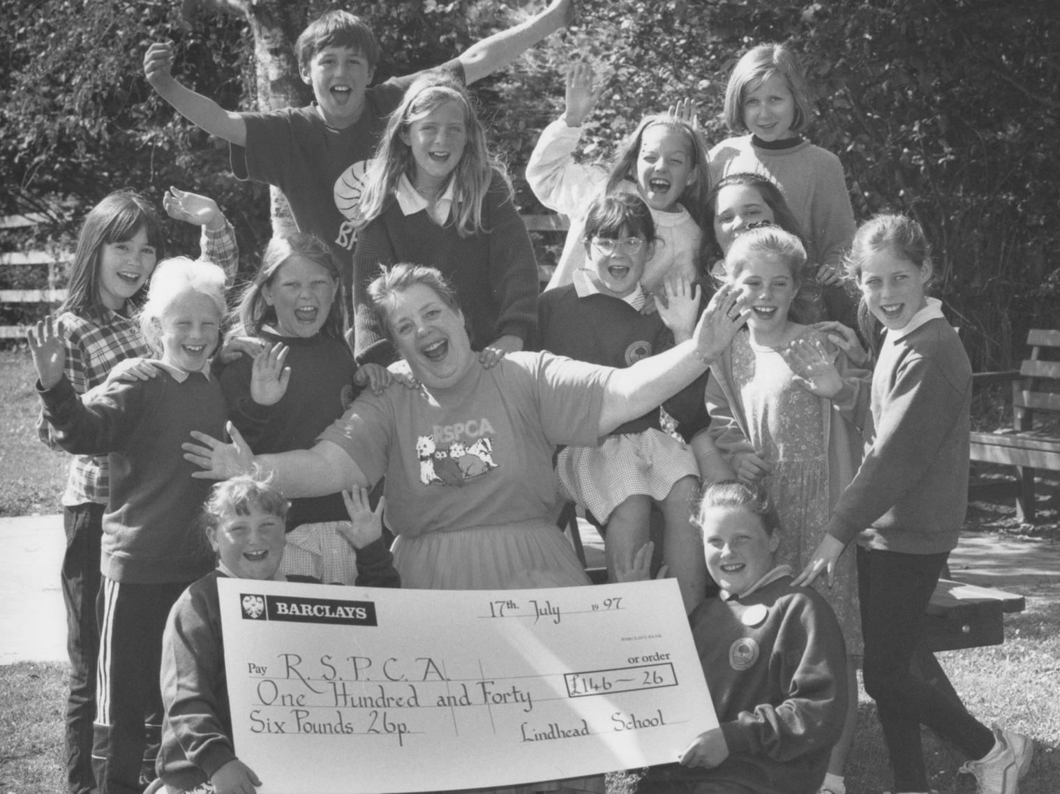 Pupils from Lindhead School handed over a cheque for 146 they raised by a sponsored swim for the RSPCA to local branch treasurer Barbara Bunfield (centre) in July 1997. Pictured with Barbara holding the cheque are sisters Sally Probert, left, and Laura Probert, who came up with the fundraising idea. They are surrounded by their fellow swimmers.