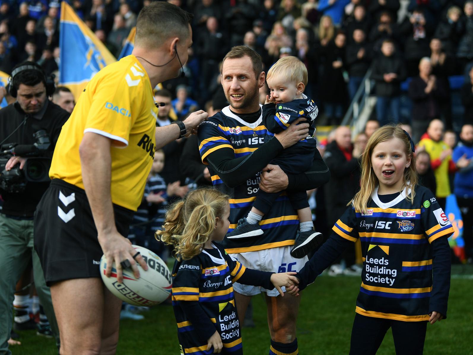 Rob Burrow on the pitch with children Macy, Maya and Jackson.