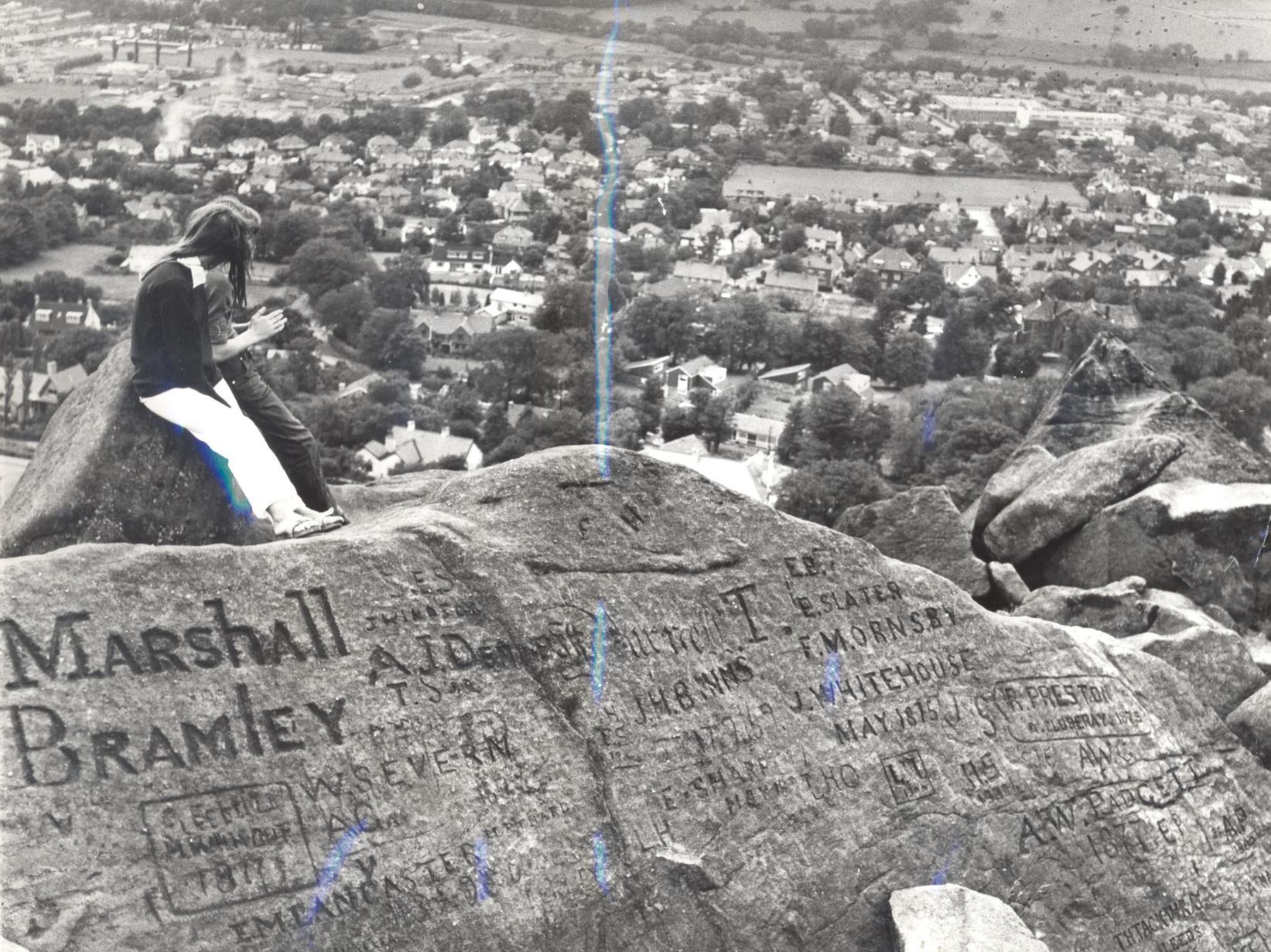 This photo was taken at the Cow and Calf rocks showing a panoramic view of Ilkley. In the foreground are a few of the names carved in the rocks.
