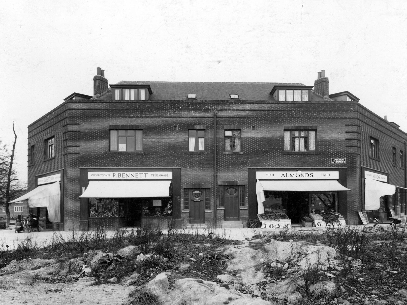A parade of shops on Amberton Approach, Oakwood Lane. From left to right, are Jarrett Bros, P. Bennett, confectioner, Almonds fish and fruit and Mittons Newsagent.