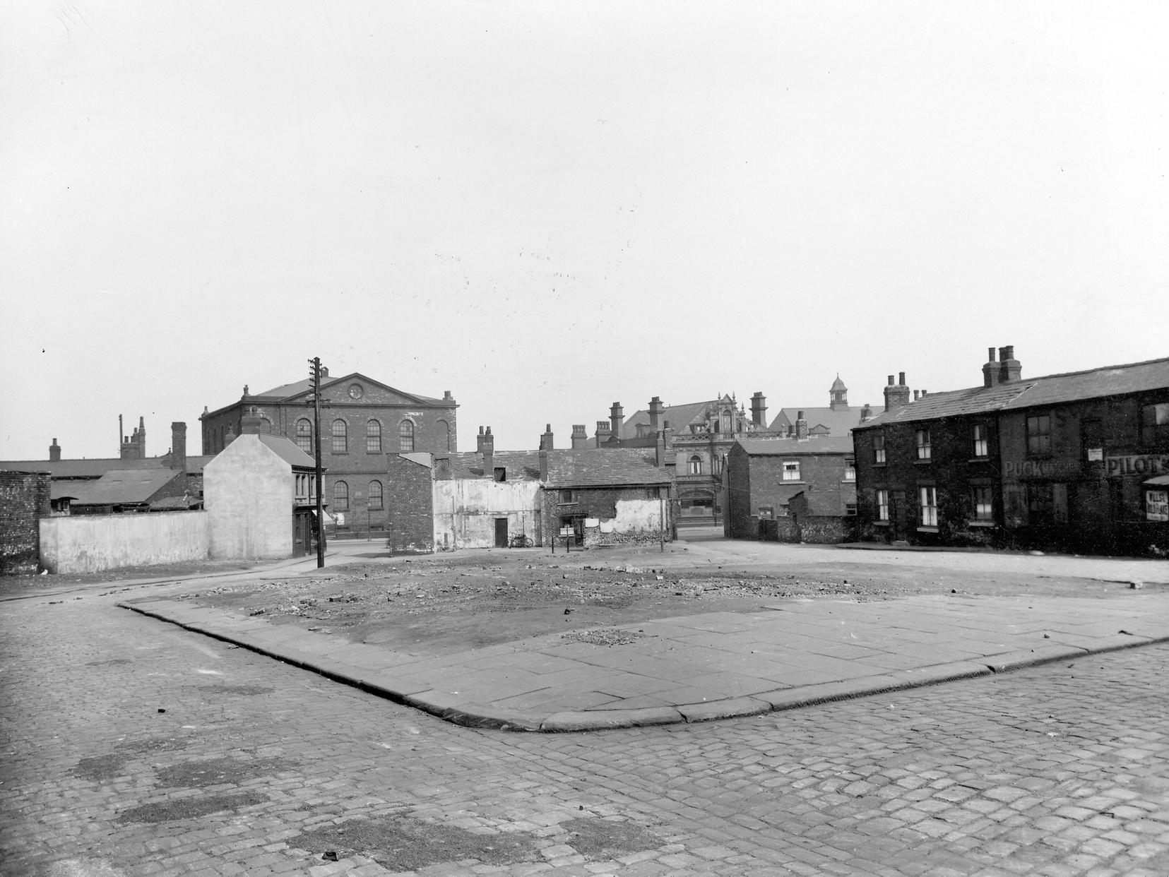 A view from Albion Terrace across waste ground, to Waterloo Road. The Garden Gate pub is just visible.