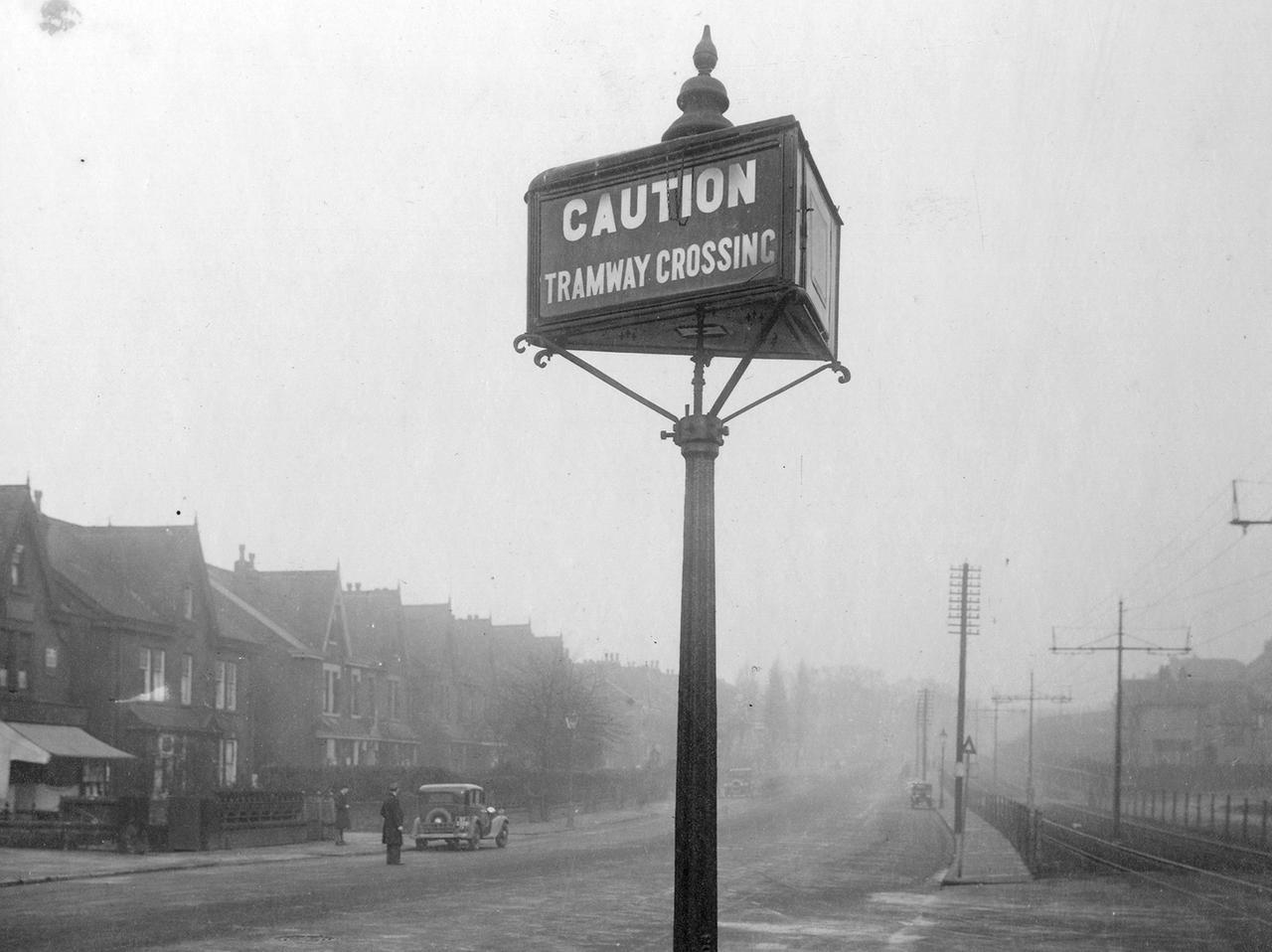 A view looking north-east along Roundhay Road focusing on a tramway caution lamp. This is at the junction with Copgrove Road where the road crosses the tramway reservation track running parallel to the main road.