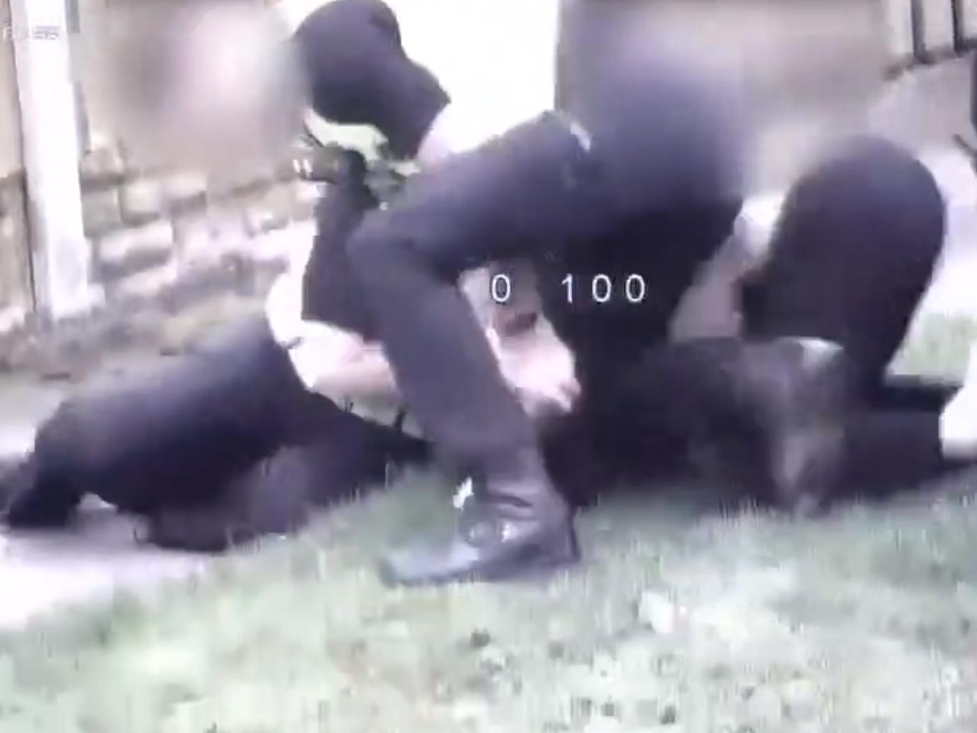CCTV shows three officers restraining David as he was arrested for obstructing an officer - one of the officers appears to sit on him as he is restrained