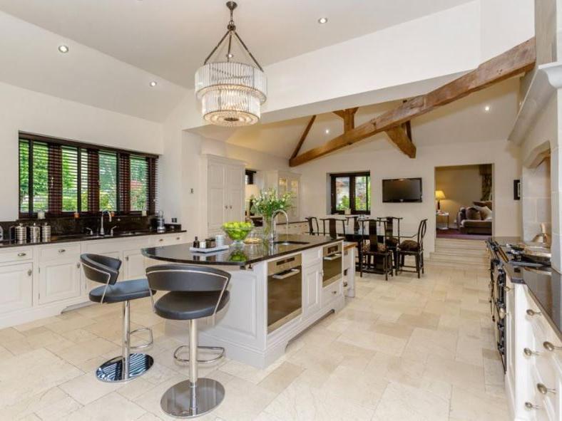 The property features a beautiful bespoke fitted dining kitchen, with underfloor heating, a central island and breakfast bar, integrated appliances, and French doors which open into the central courtyard.