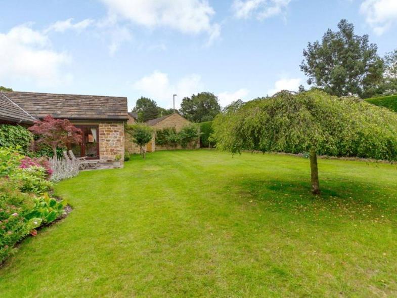 The property features neat and well tended lawns to the front, with a private, enclosed lawned garden on the south side, along with conifer hedging, a stone paved sun terrace and a small orchard with a variety of fruit trees.