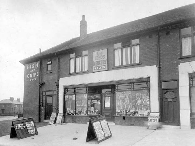 A newsagents at end of a parade of shops on Potternewton Lane. There are newspaper boards on the outside for the Yorkshire Post, Evening News, Leeds Mercury and Daily Mail. Scott Hall Road is to the left.