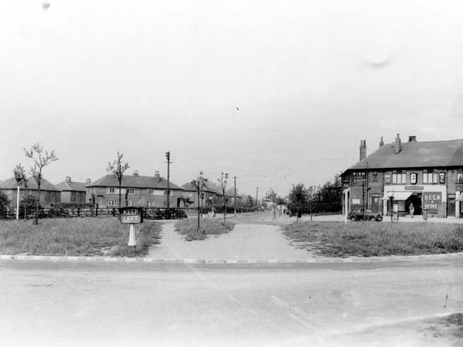 A view of Scott Hall Road and Potternewton Lane. Shops on the right are Fred Dawson Fish and Chip shop (on corner) with Jackson's grocers next door.