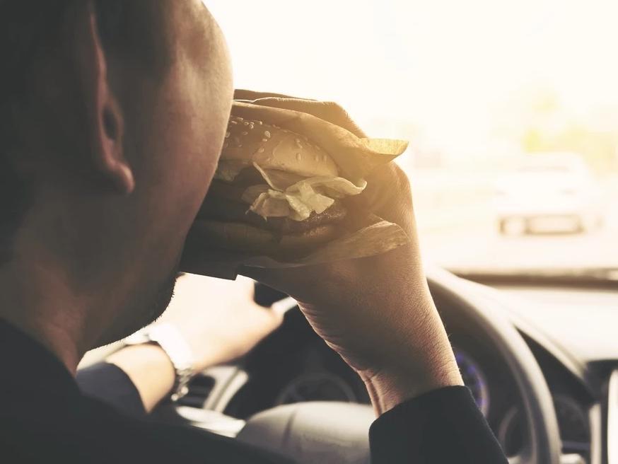Eating and driving isnt illegal but if youre caught being distracted you could be fined 100. If you plan on going through a drive-through, you must also remember not to pay with your phone if your engine is on, as this is illegal.