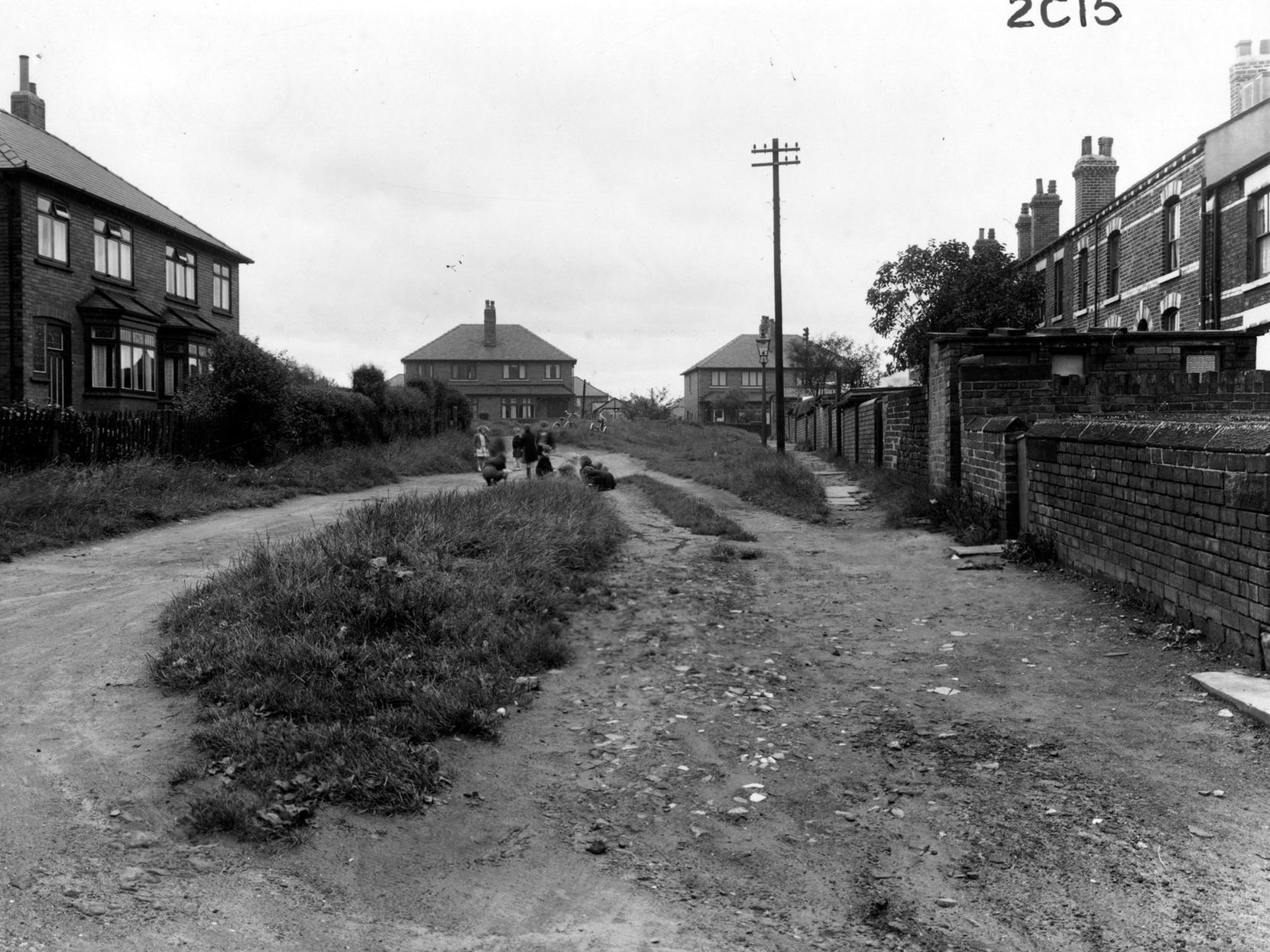 Back Mount Pleasant in Middleton looking west onto Lingwell Crescent. Children are playing in the street, with a bicycle and tricycle in the background.