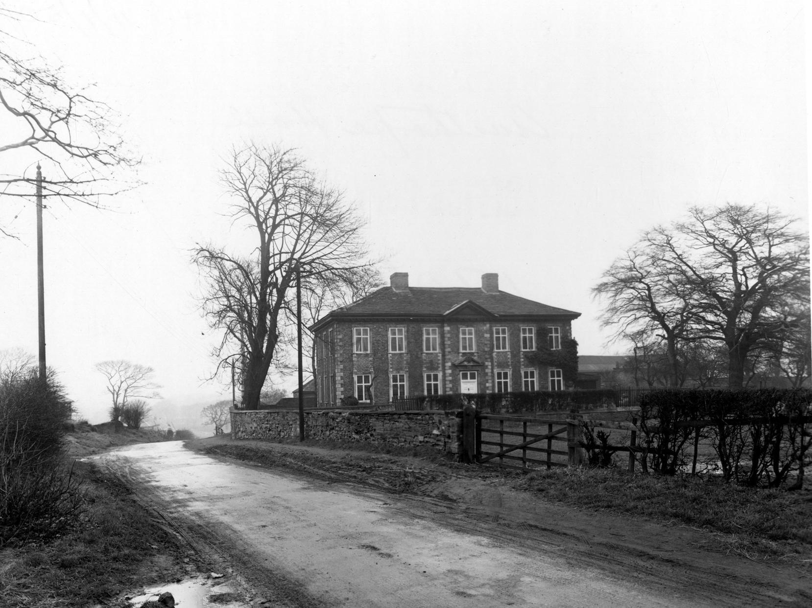 Austhorpe Hall from muddy road across a field towards the house. The left hand side of the road was shortly to be developed into a row of semi-detached houses.