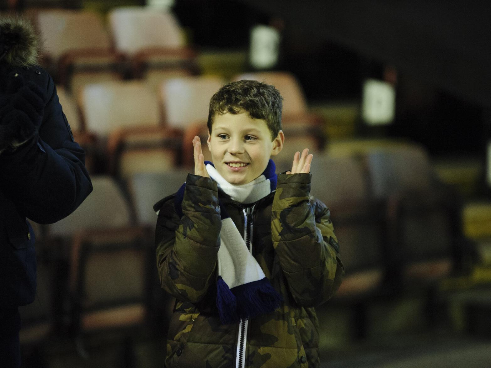 A young North Ender has a big smile as he's wrapped up to watch his side.