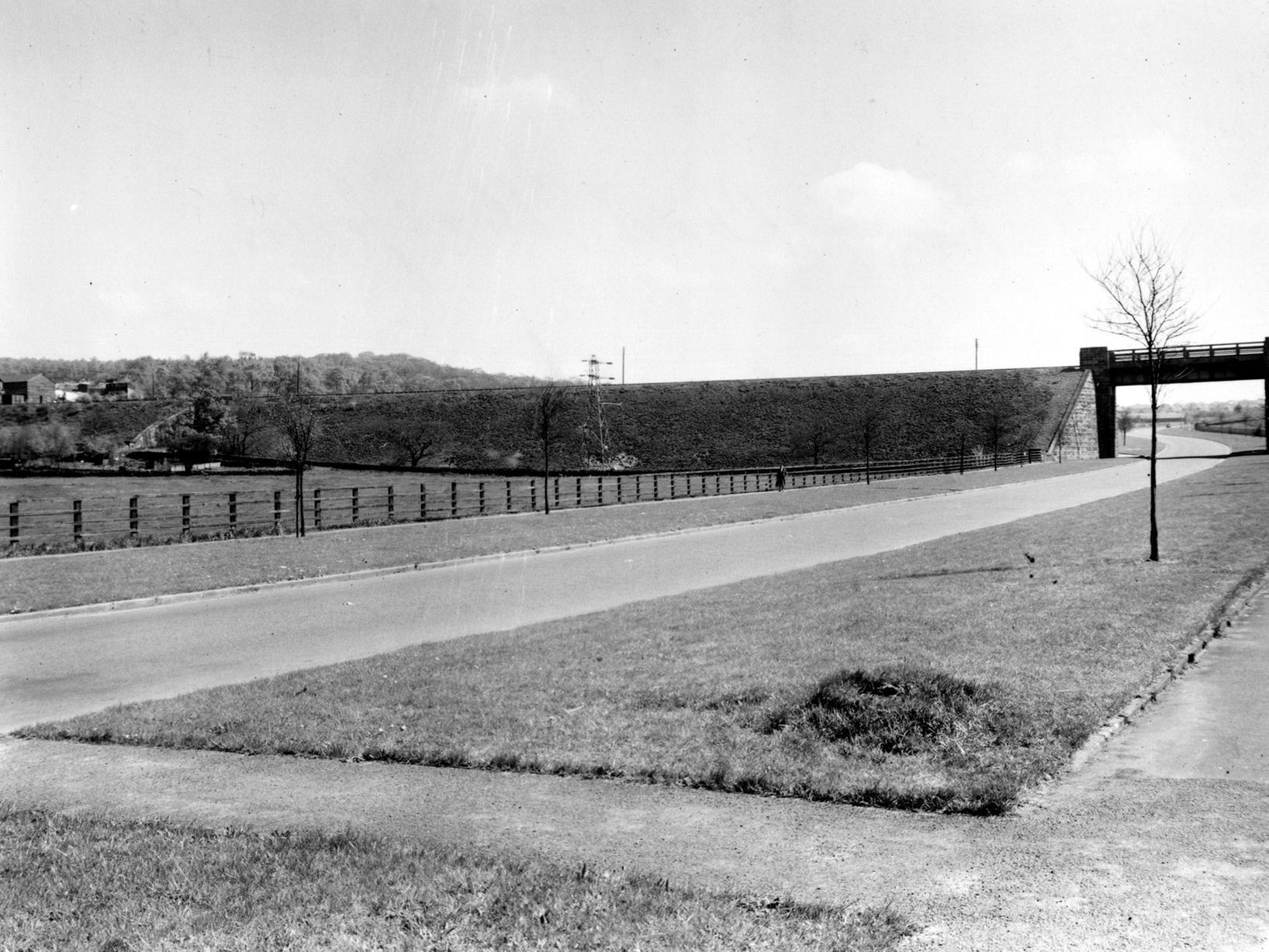 The L.N.E.R. Railway Bridge over the Horsforth Ring Road between Horsforth and West Park, looking north-east. A tree is to the right, an electricity pylon is in the centre and a signal box and commercial buildings are to the left.