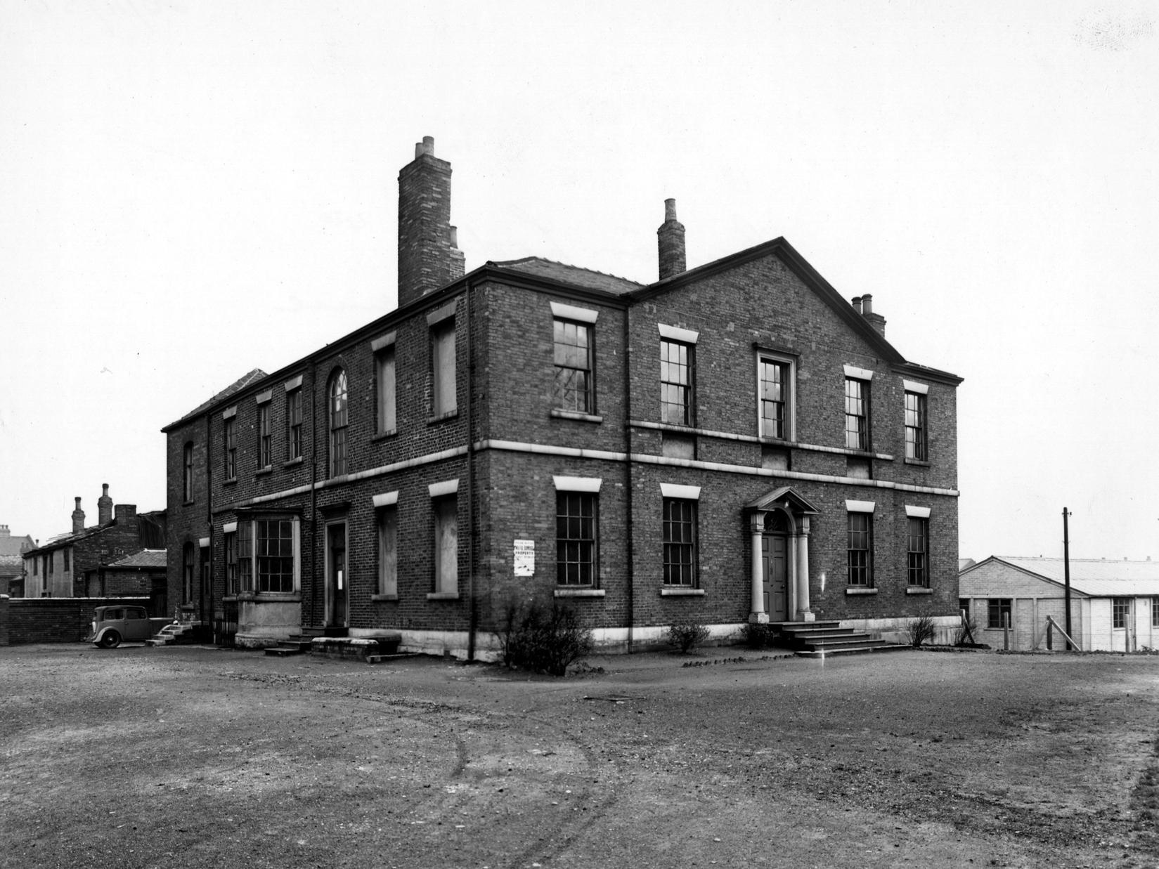 Burton Lodge on Burton Avenue off Dewsbury Road in Hunslet. The building is a large Georgian house with an extension to the rear. A parked car can be seen on the left.