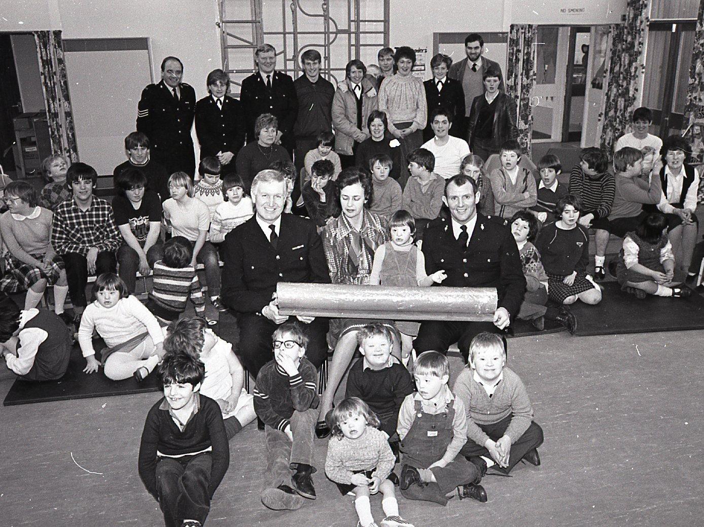 Police have come to the aid of The Coppice School in Bamber Bridge, who were in need of a major cash boost. Preston bobbies donated a four foot stick of rock they won in a TV contest, which will be raffled to provide funds for a minibus. Chief Supt Ken Mackay, left, and PC Alan Corlett present headmistress Miss Janice Harrison with the jumbo-sized rock. On PC Corlett's left is his daughter Shelley