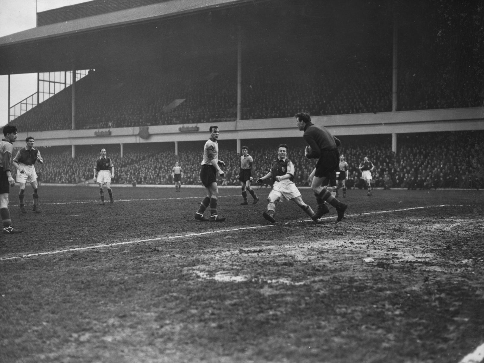 Leeds defender, Charles, watches his goalkeeper, Wood, take the ball ahead of West Ham United player, Dare, as West Ham United play Leeds United at Upton Park.