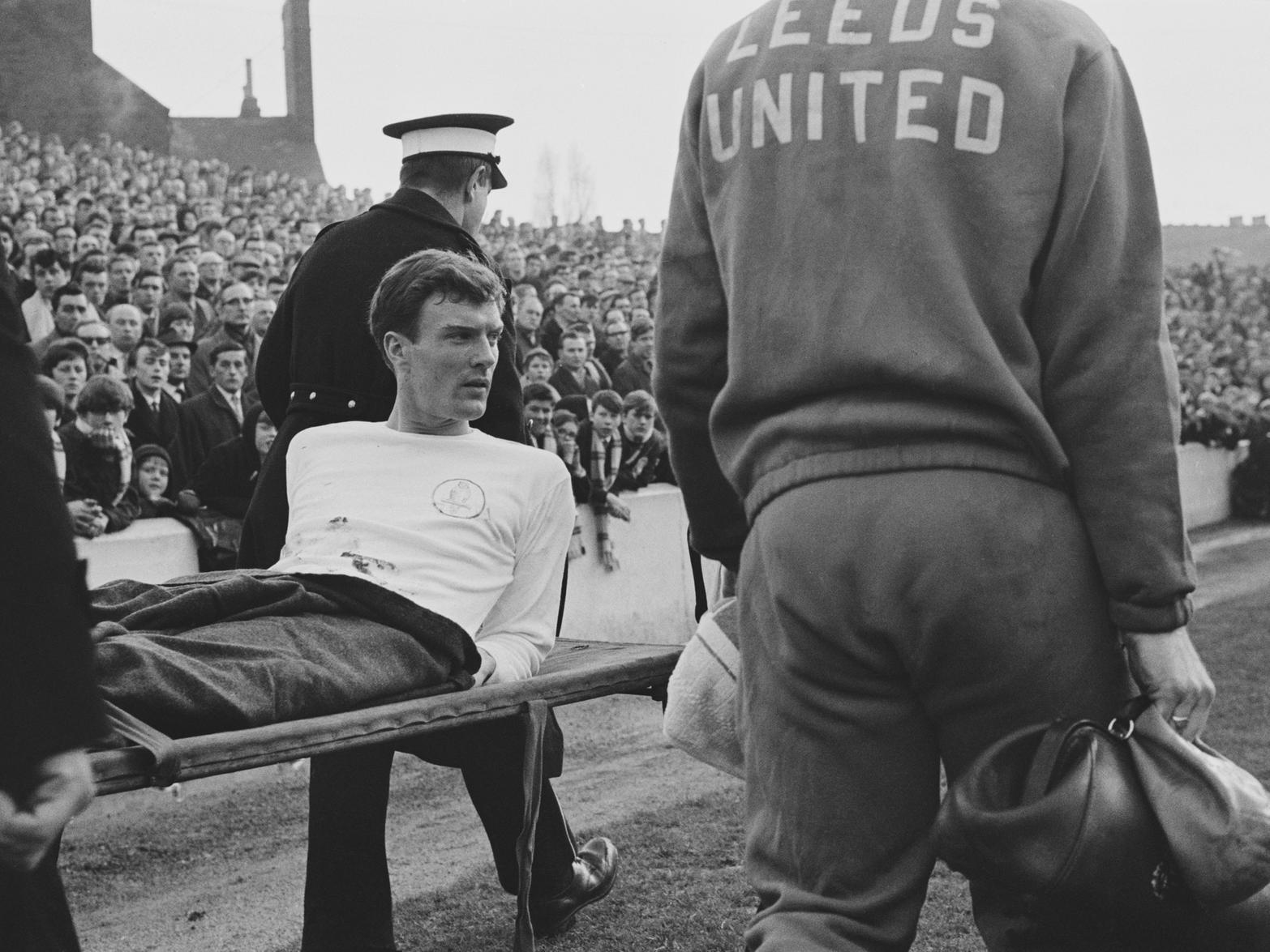 Footballer Paul Madeley of Leeds United is carried off after an injury during a League Division One match against Nottingham Forest