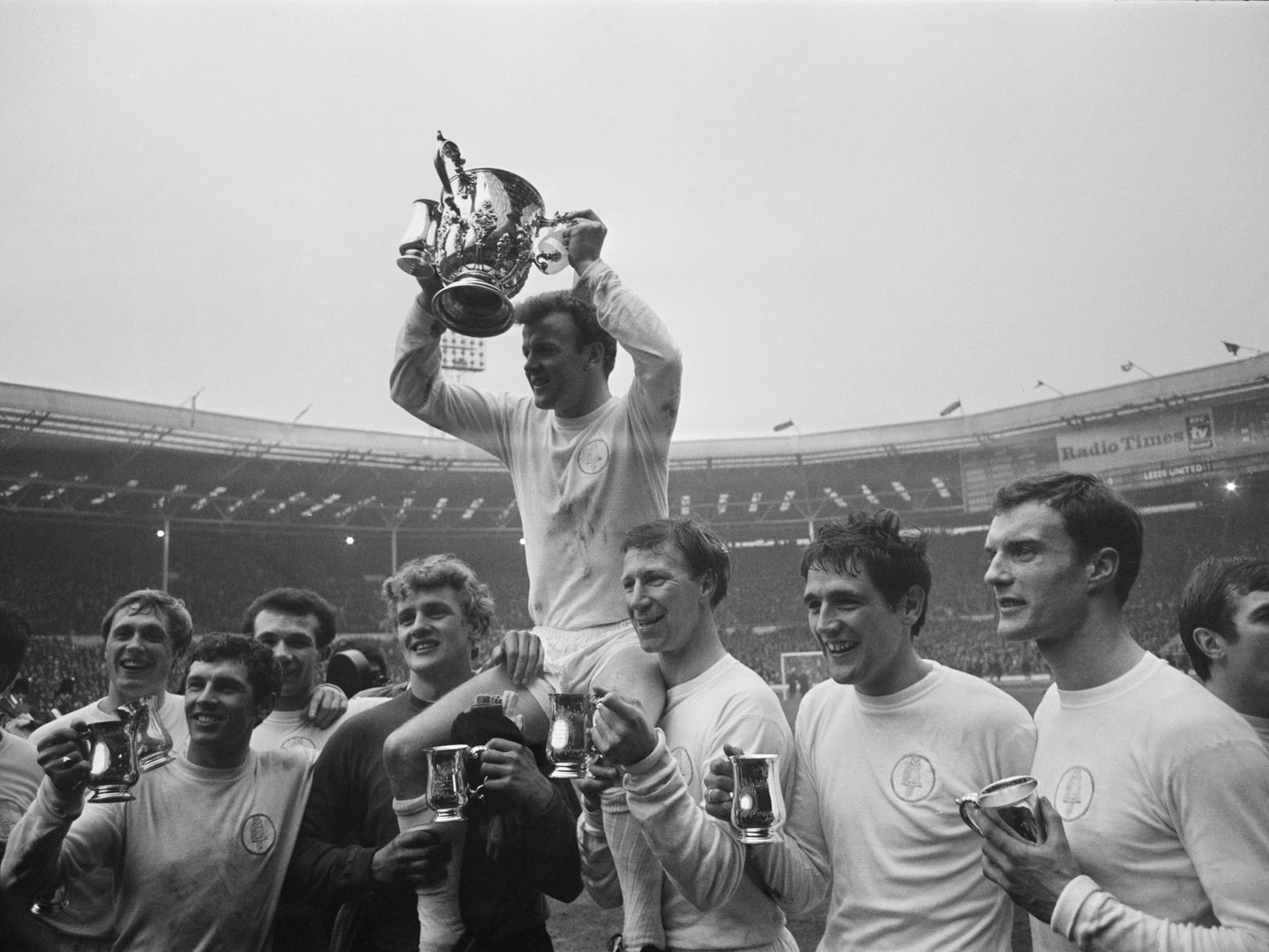 Leeds United captain Billy Bremner (1942 - 1997) and fellow players hold trophies after winning the League Cup final against Arsenal.