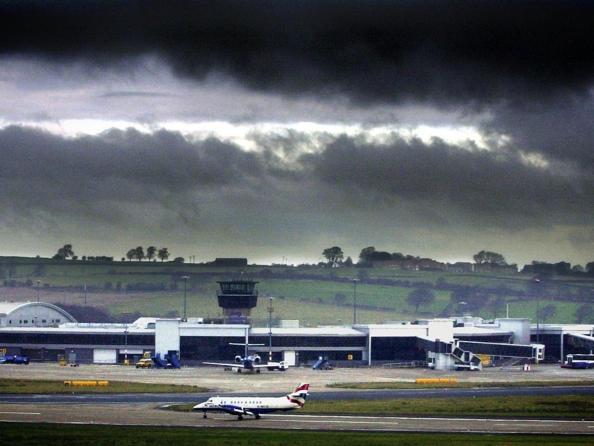 A British Airways plane taxis along the runway as dark clouds loom over Leeds Bradford Airport, on the day that BA announced the cutting of flights from the airport.
