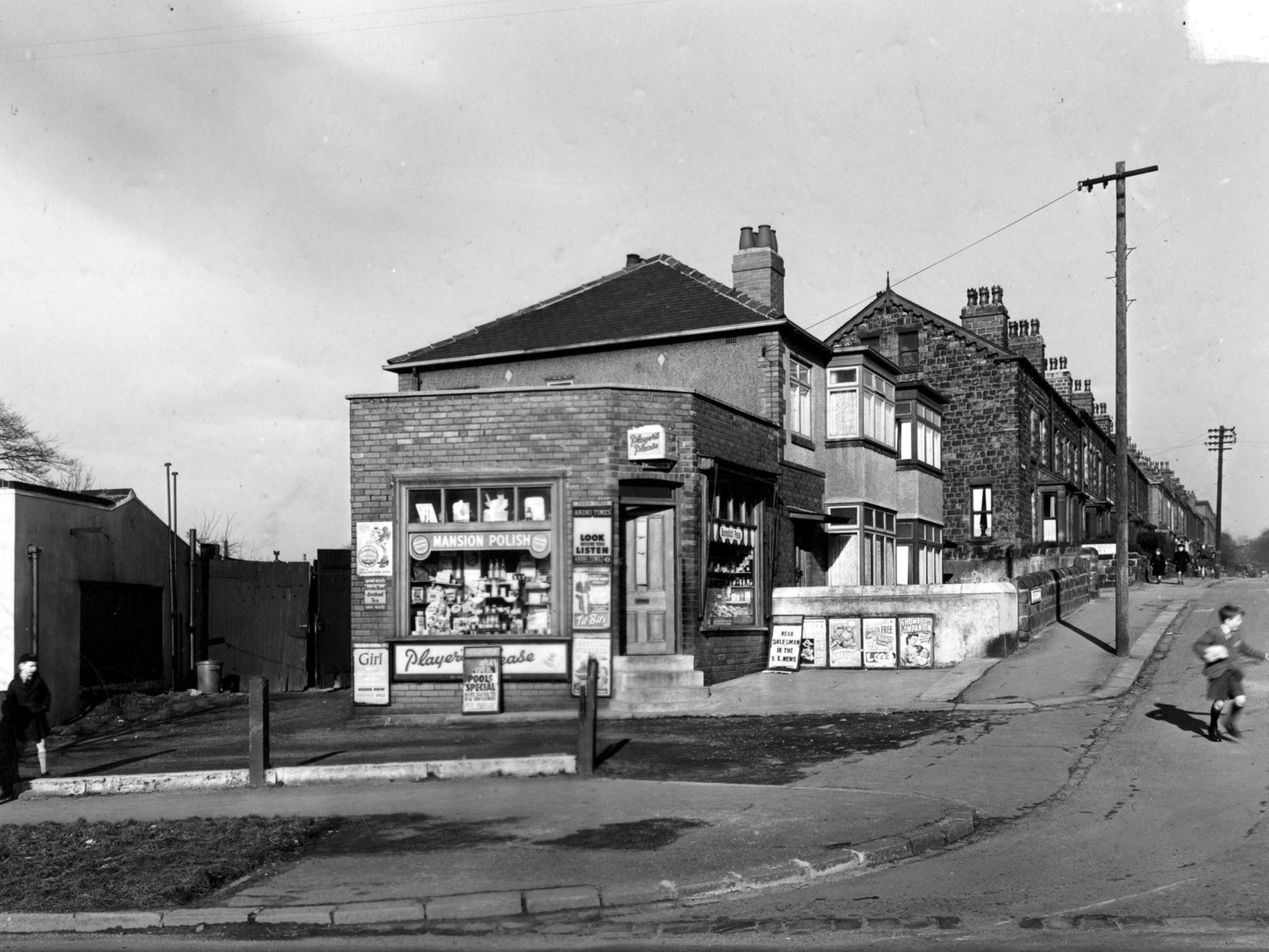 Junction of Bentley Lane with Grove Lane in Meanwood, showing a pair of semi-detached houses, with the premises of E. Hawkshaw, newsagent, on the end.
