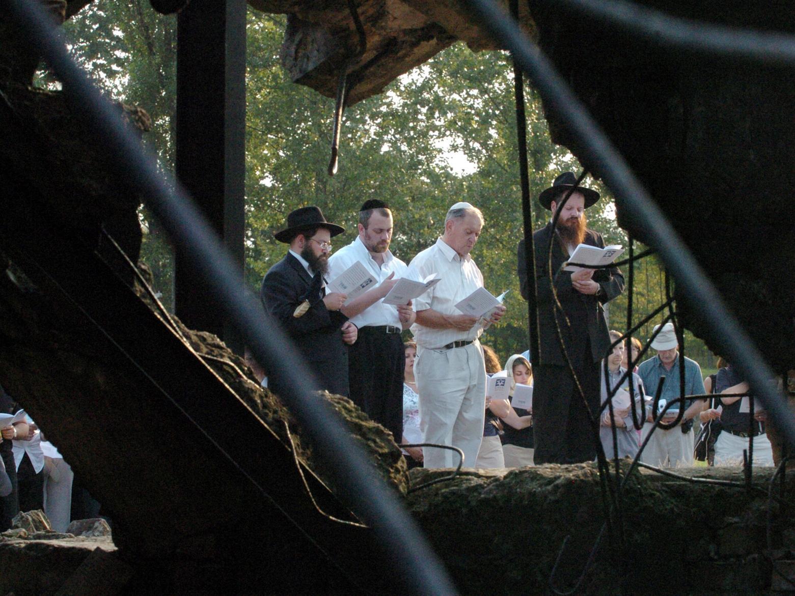 The delegation hold a service by the destroyed crematoria. Pictured, at the front, are Rabbie Mendel Sufrin, Rabbi Daniel Levy, Arek Hersh and Rabbi Shalom Krafchik.