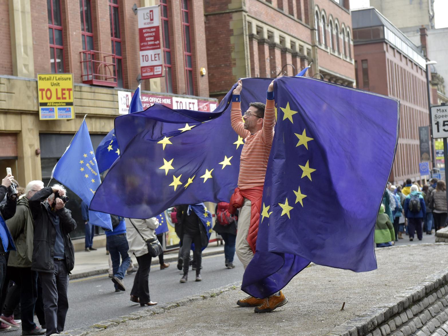 A protester hoists EU flags on The Headrow during a 'Stop Brexit' rally