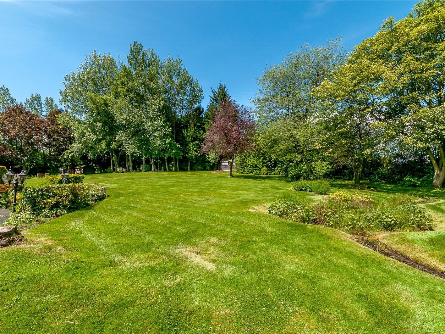The grounds extend to approximately two and a half acres, and are beautifully kept and well enclosed in order to offer total privacy