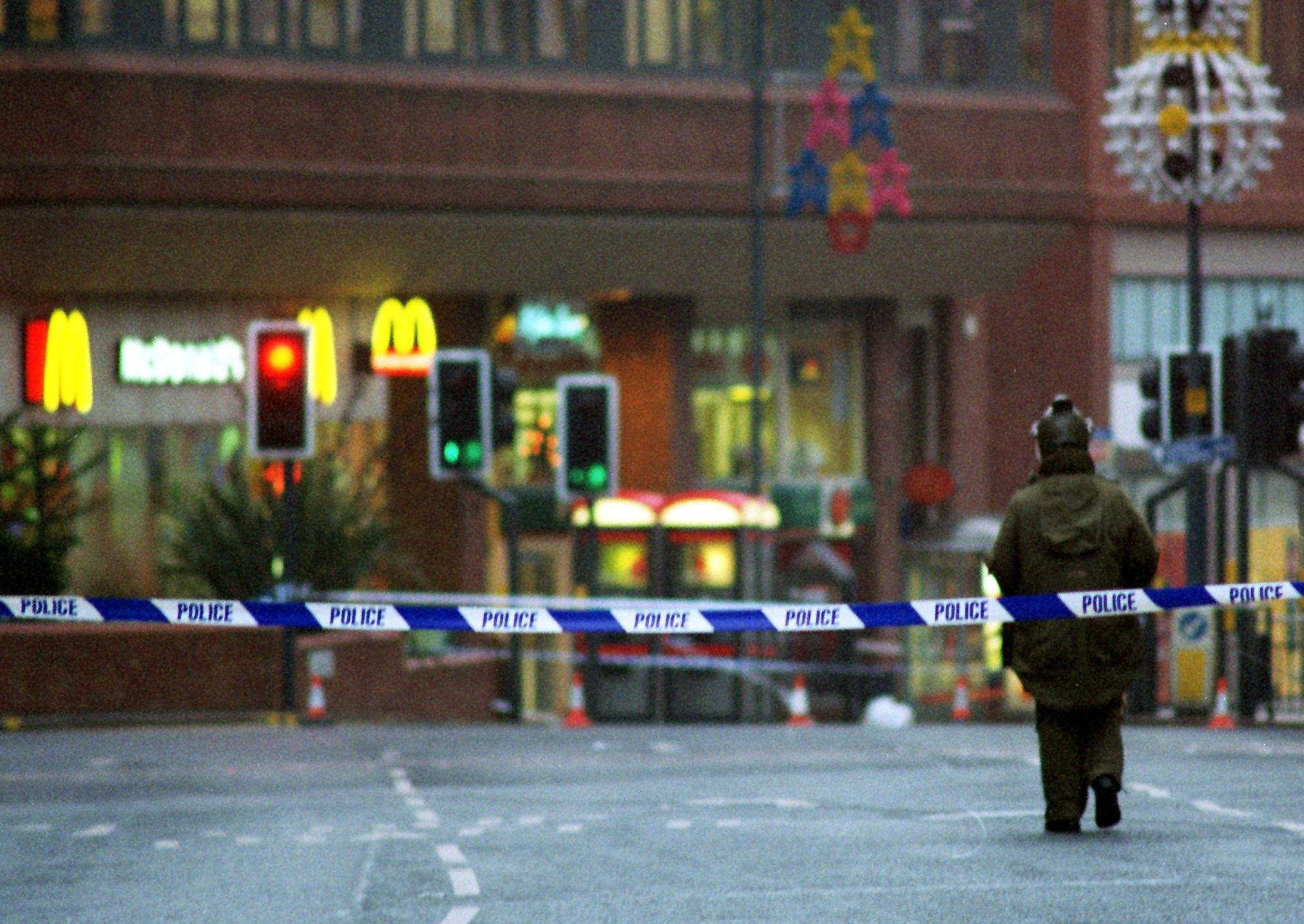 A bomb disposal officer makes his way through a cordon after a suspicious package was discovered at McDonald's in the St John's Centre.