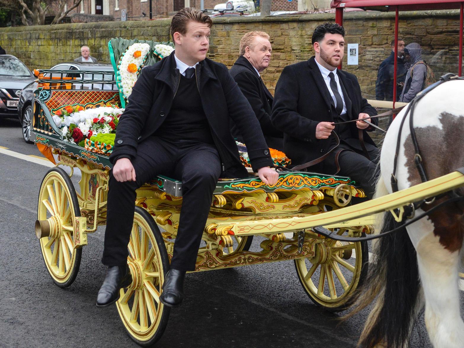 Mourners travel on a horse-drawn carriage to the church cc SWNS
