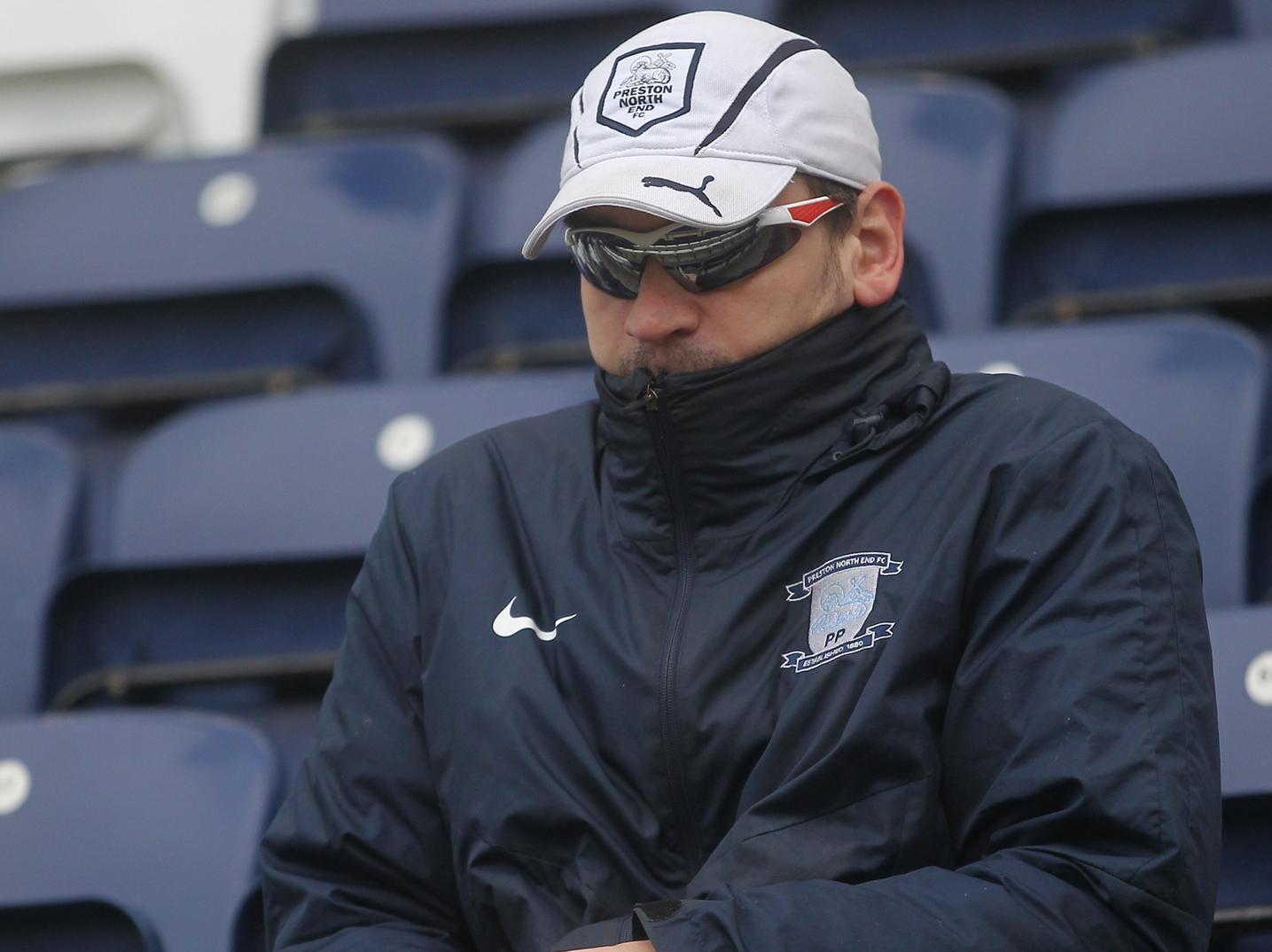 A PNE fan hunches up from the cold on a blustery day in PR1.