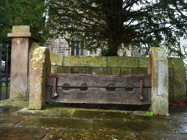 Village stocks, probably 18th century, restored 1902 to commemorate coronation of Edward VII