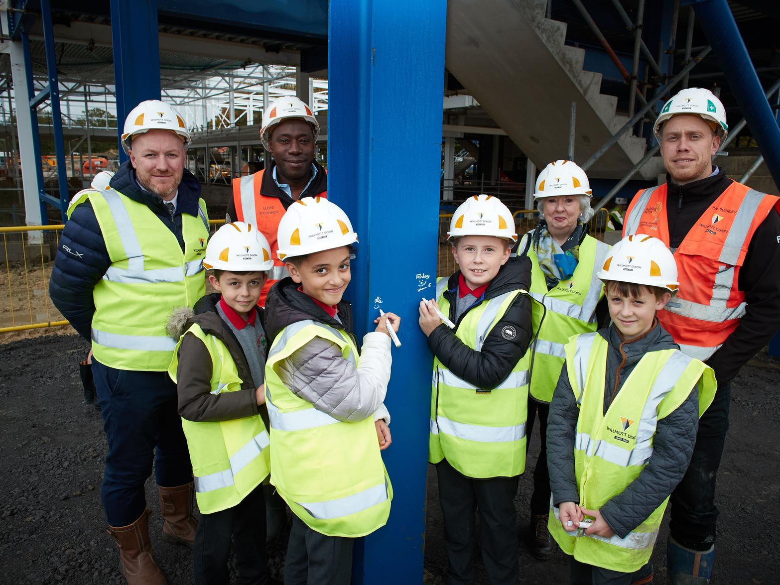 As construction continued, more than 30 pupils from St Giles C of E Academy were invited to visit the site, where they were offered the opportunity to sign their names onto the building's foundations.