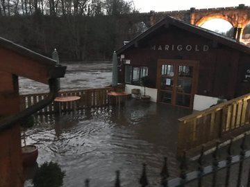 The rising flood water at the Marigold Cafe along the waterside.