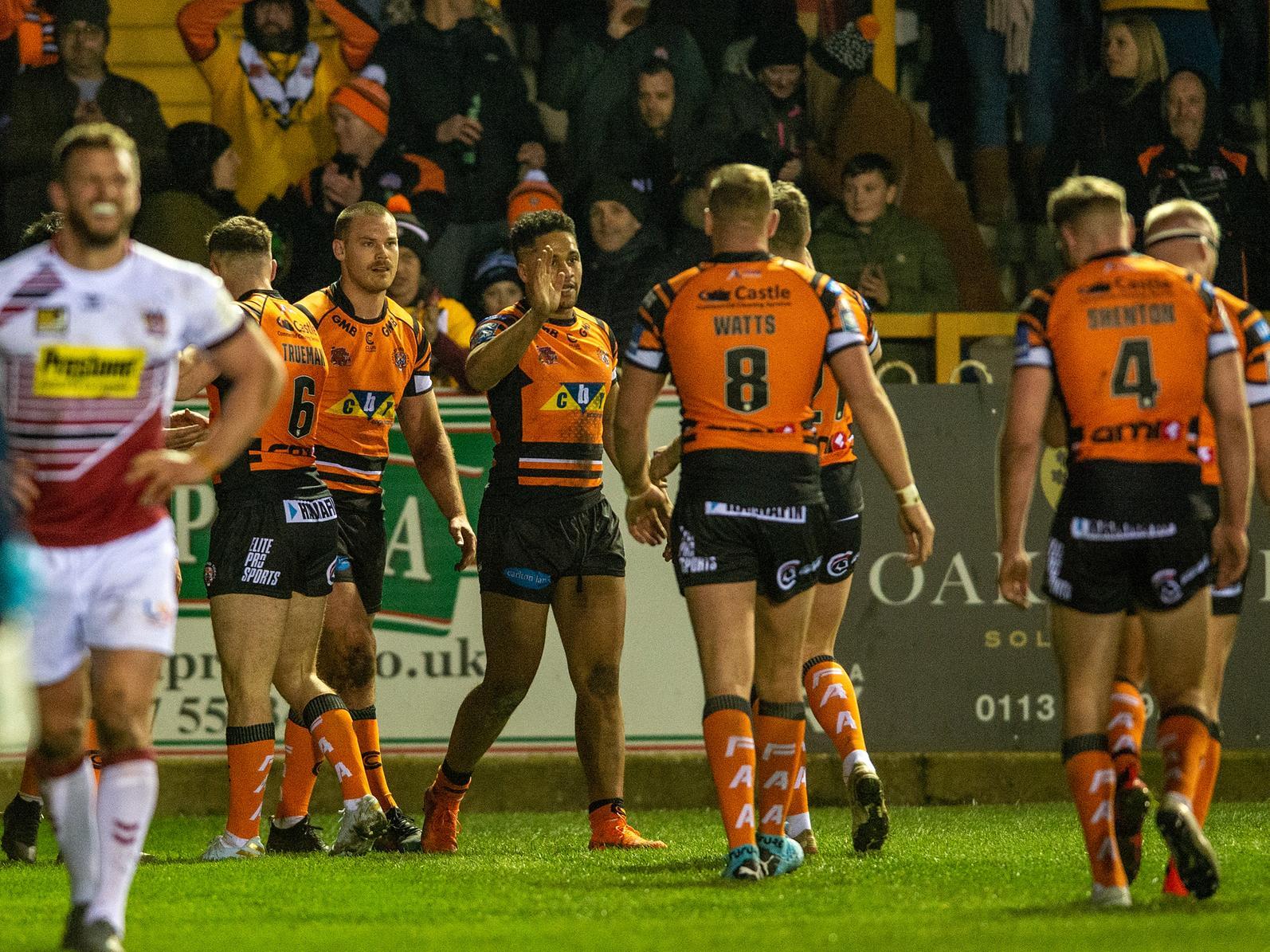 Derrell Olpherts, third Tigers player from left, celebrates his try against Wigan. Picture by Bruce Rollinson.