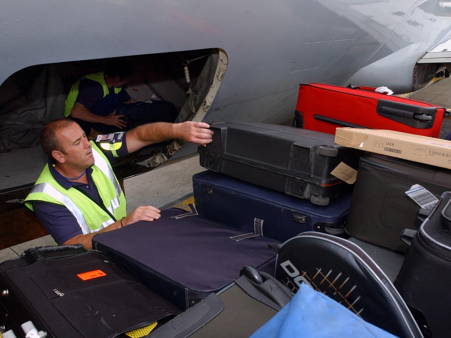 Baggage handlers load up an aircraft.