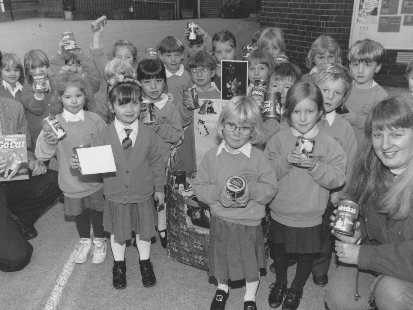 Children from Gladstone Road Junior and Infant School held a collection of tinned cat foods at their school in December 1995. The Infants are pictured with some of the tinned cat foods and their teacher Mark Thompson and his wife Sue, who organised the collection.