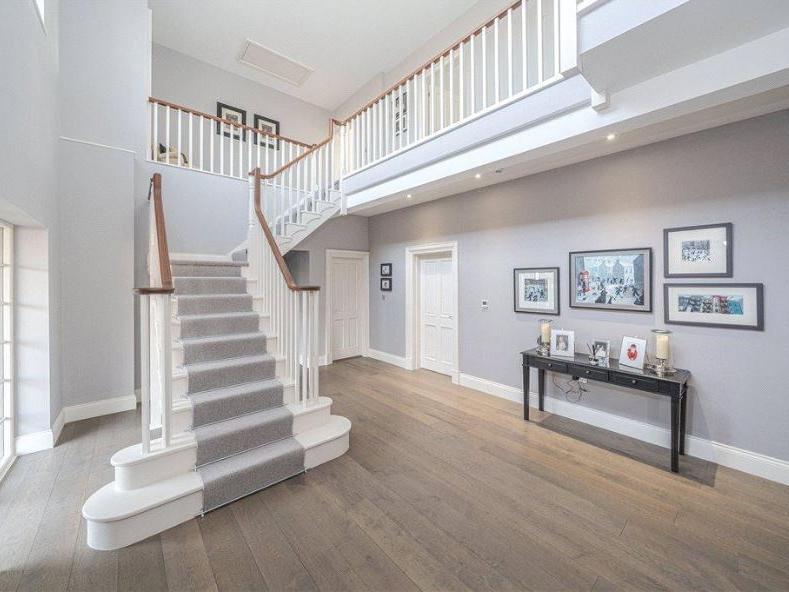 The double height hallway offers an abundance of light and features an elegant staircase, which leads to a galleried landing area, with strip oak wood flooring lining the entrance.