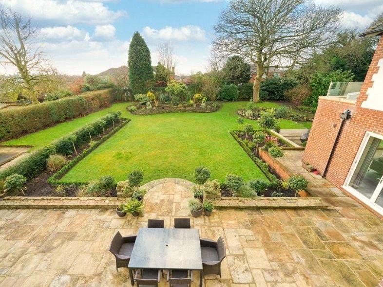 The beautifully landscaped garden sits surrounded by mature trees to offer a great level of privacy. It features a tiled patio area with a table for al-fresco dining.