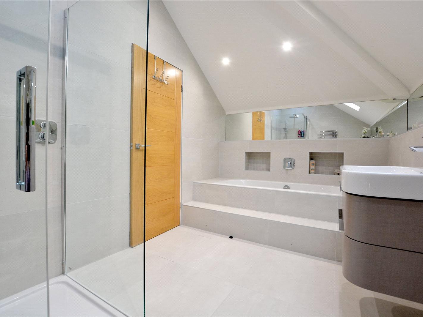 A modern five piece suite including bath, separate shower, bidet, and wash hand basin.