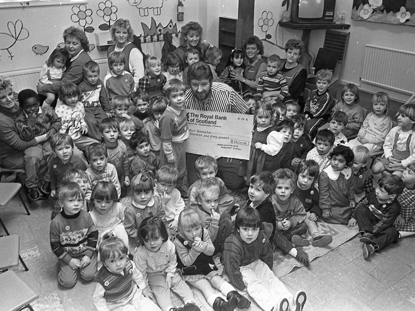 Toddlers James Glennoe and Laura Edwards found they needed a helping hand when they presented a giant-sized cheque for 140 to Doctor Barnardo's. Luckily Preston councillor Frank McGrath was around to ease the burden on behalf of the charity. The three-year-olds, of Marylands Private School, Penwortham, were watched by their classmates who helped raise the money through a Christmas nativity play and raffle