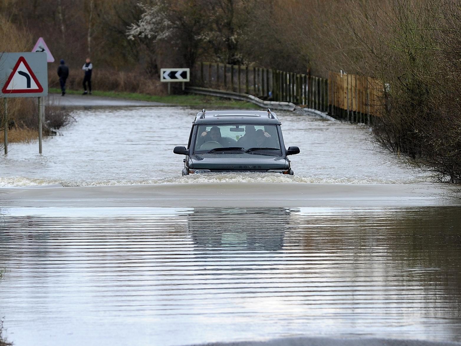 A car drives through flooded road on Newton Lane, Fairburn Ings