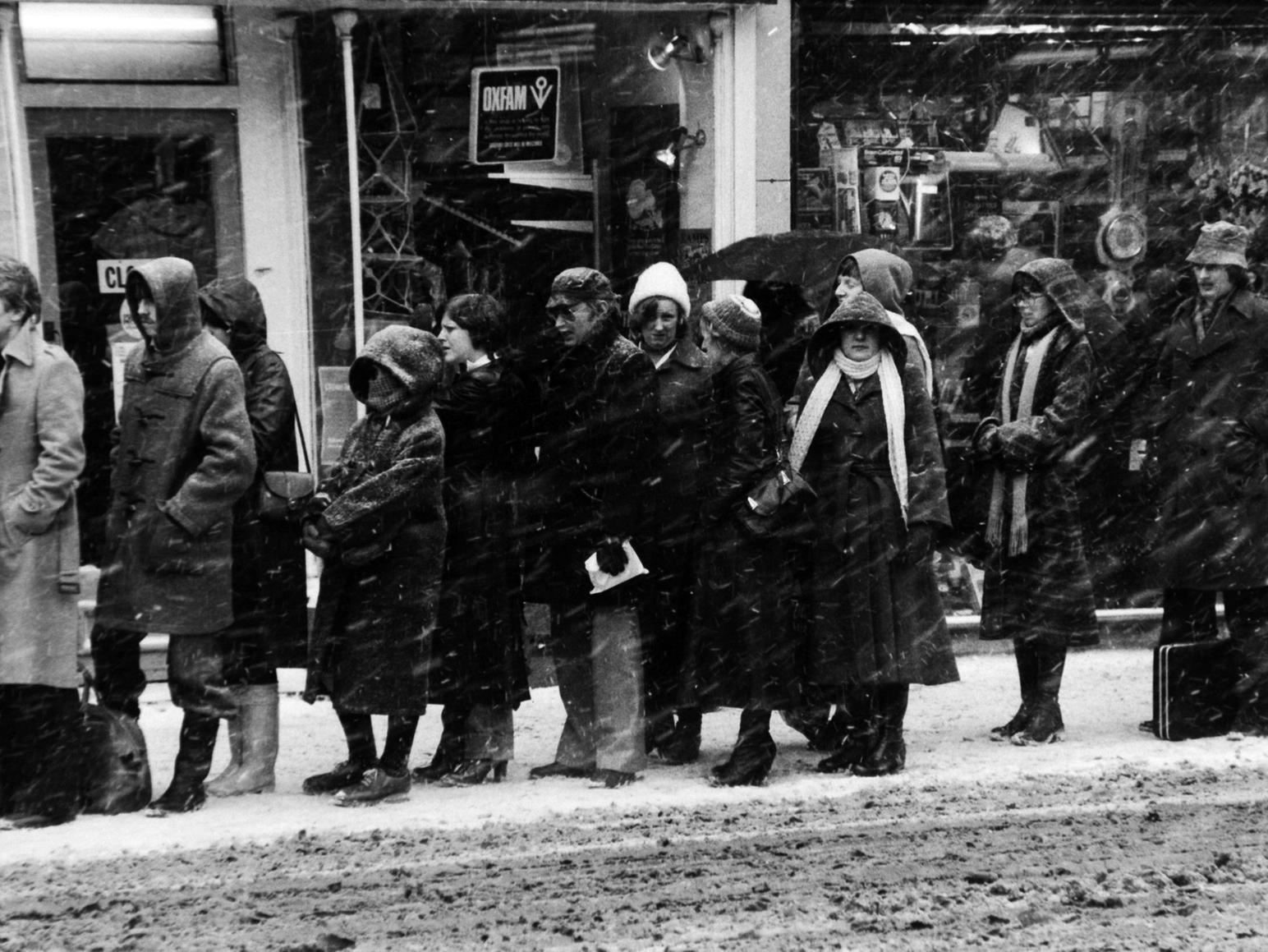Blizzard conditions on Boar Lane as people queue for a bus to transport them home as the city evening rush hour begins.