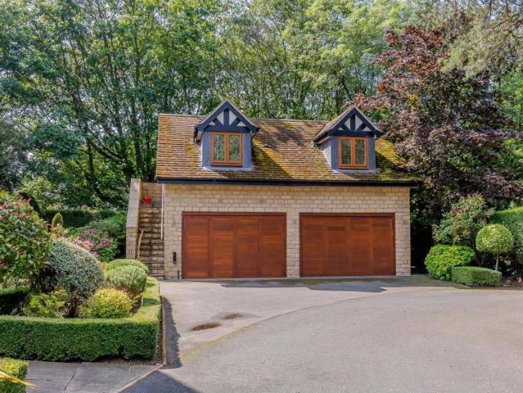 The property boasts a driveway with ample capacity for parking and garaging for up to six vehicles.