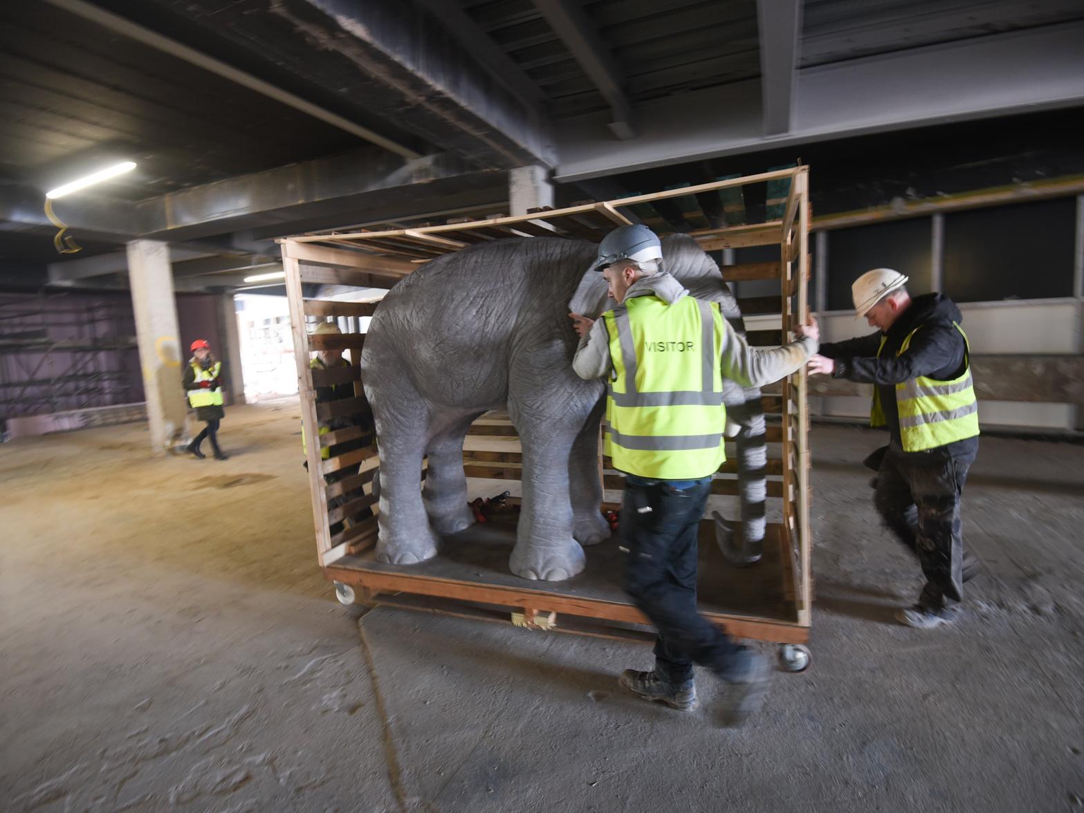 Workers move the crate into position on the first floor