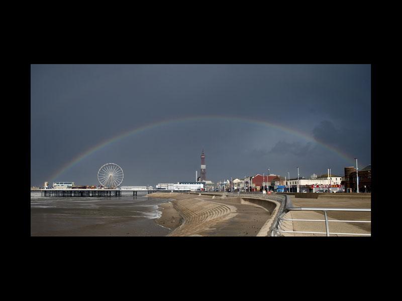 A rainbow appears over Blackpool's Central Pier in stormy conditions in Blackpool, north west as the tail end of Hurricane Gonzalo brought high winds and travel disruption to Britain (OLI SCARFF/AFP via Getty Images)
