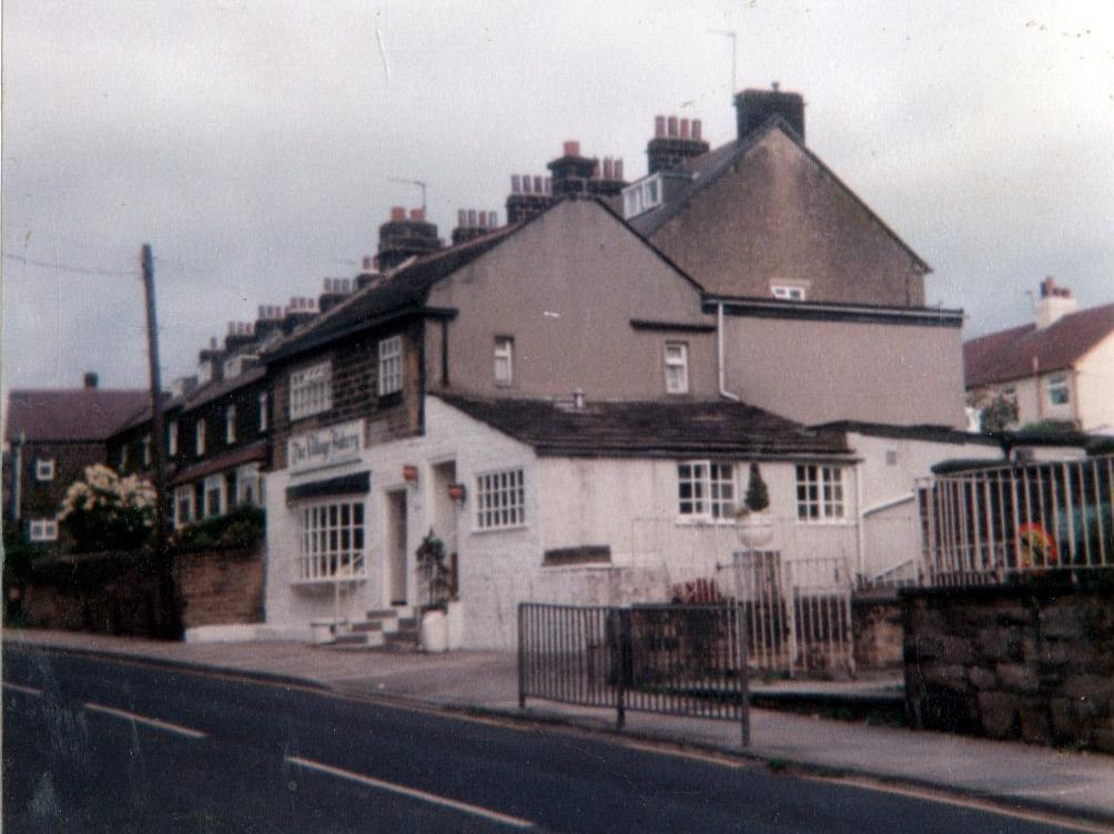 The white painted building in the centre is Rawdon's village bakery. On the right is entrance to St. Peter's Junior and Infant School.