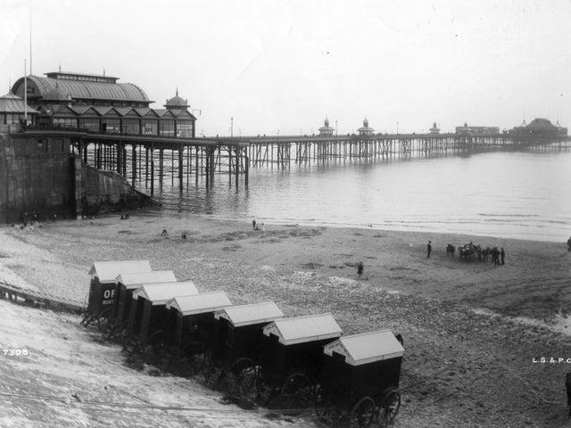 Bathing machines lined up on the beach in front of the North Pier in 1900